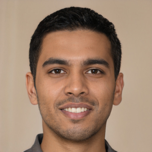 Joyful latino young-adult male with short  black hair and brown eyes