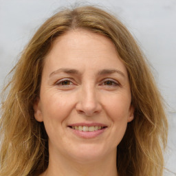 Joyful white adult female with long  brown hair and brown eyes