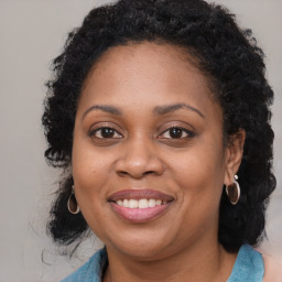 Joyful black adult female with long  brown hair and brown eyes