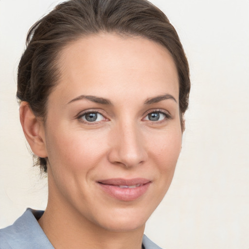 Joyful white young-adult female with medium  brown hair and grey eyes