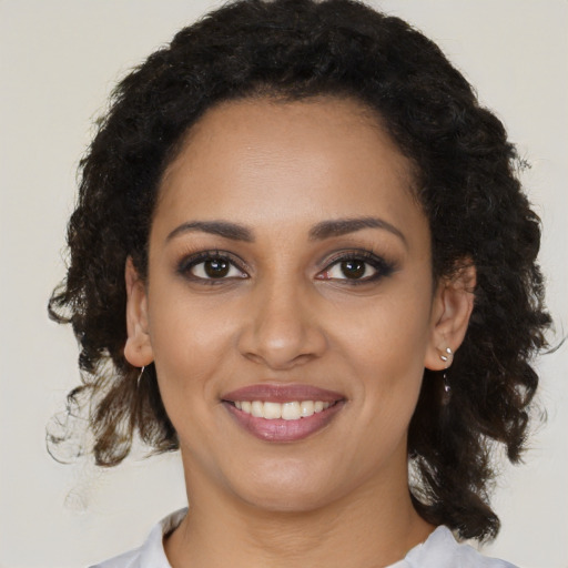 Joyful black young-adult female with medium  brown hair and brown eyes