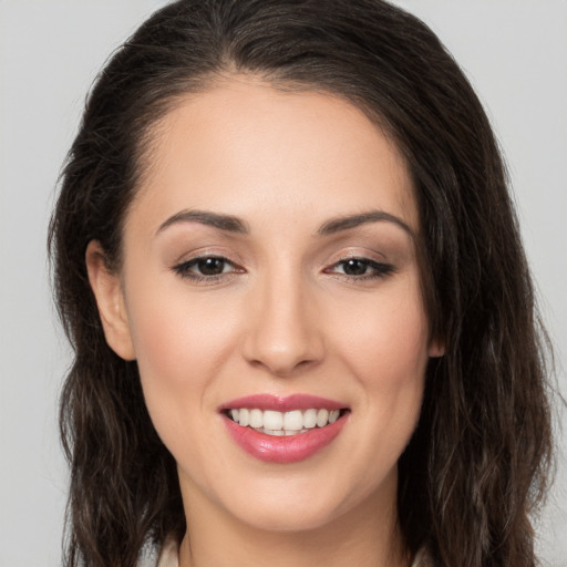 Joyful white young-adult female with long  brown hair and brown eyes