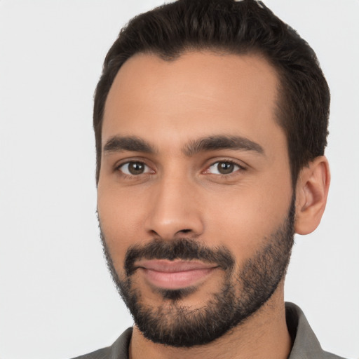 Joyful latino young-adult male with short  black hair and brown eyes