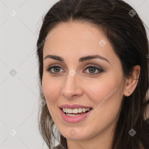 Joyful white young-adult female with long  brown hair and brown eyes