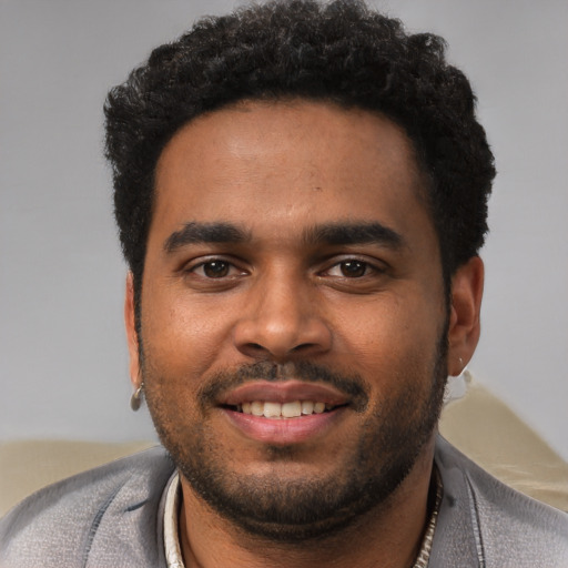 Joyful black young-adult male with short  black hair and brown eyes