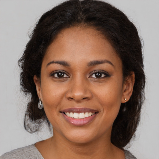 Joyful black young-adult female with medium  brown hair and brown eyes