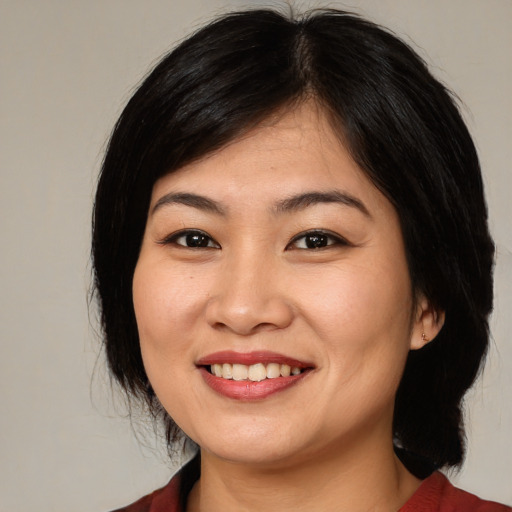 Joyful asian young-adult female with medium  black hair and brown eyes