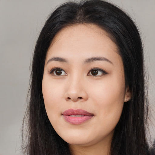 Joyful asian young-adult female with long  brown hair and brown eyes