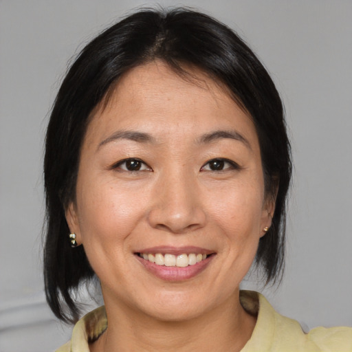 Joyful asian adult female with medium  brown hair and brown eyes