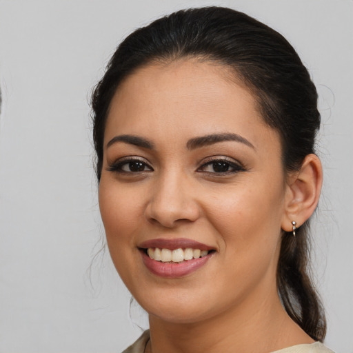 Joyful latino young-adult female with medium  brown hair and brown eyes