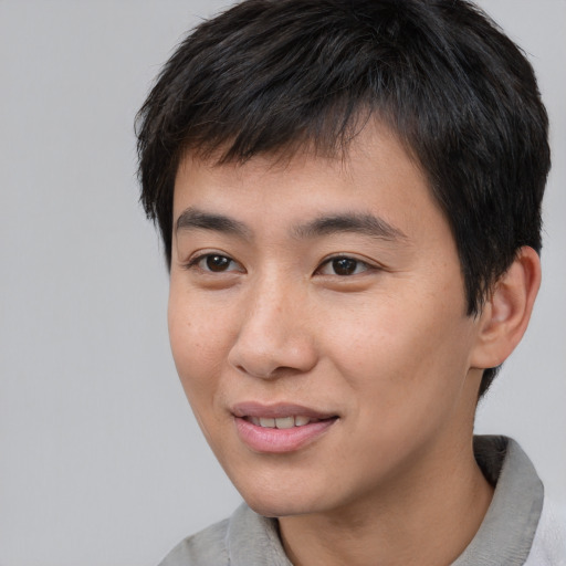 Joyful asian young-adult male with short  black hair and brown eyes