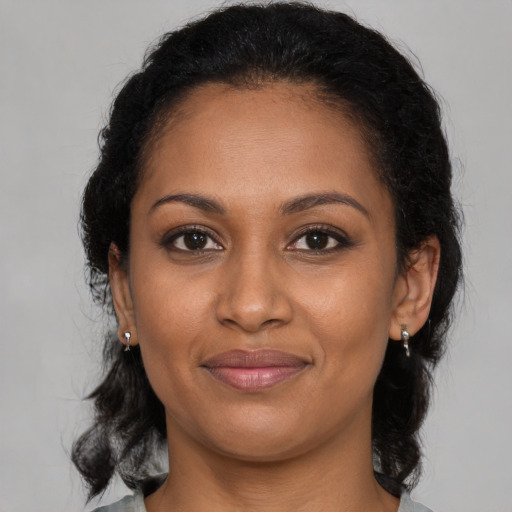 Joyful black adult female with medium  brown hair and brown eyes