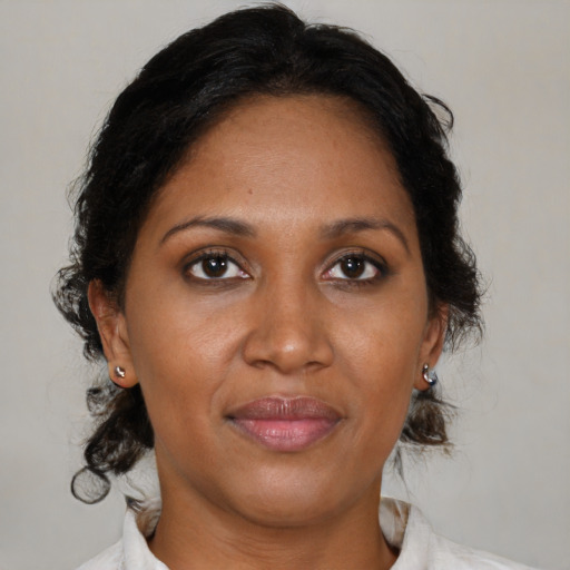 Joyful black adult female with medium  brown hair and brown eyes