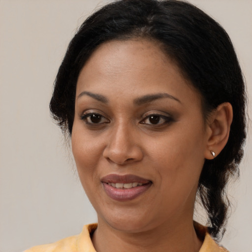 Joyful latino adult female with medium  black hair and brown eyes