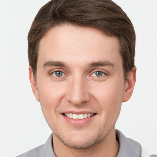 Joyful white young-adult male with short  brown hair and grey eyes