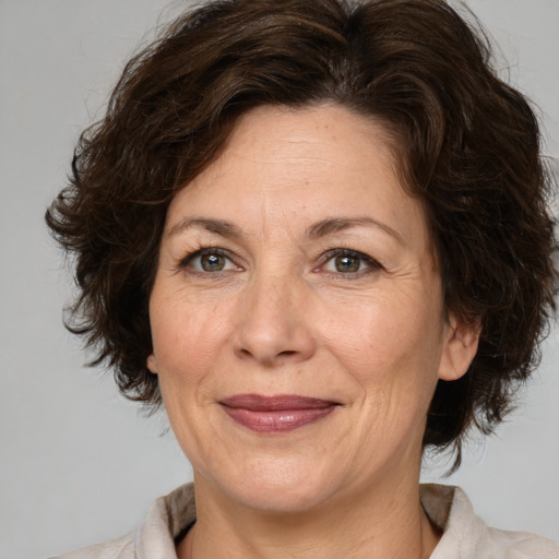 Joyful white adult female with medium  brown hair and brown eyes