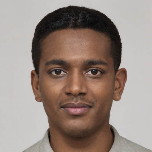 Joyful black young-adult male with short  black hair and brown eyes