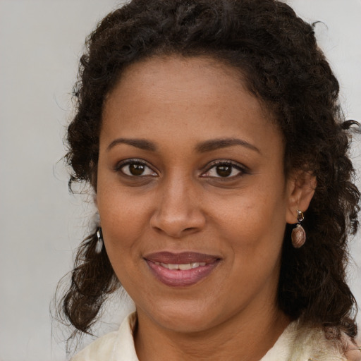 Joyful black young-adult female with medium  brown hair and brown eyes