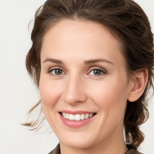 Joyful white young-adult female with medium  brown hair and green eyes