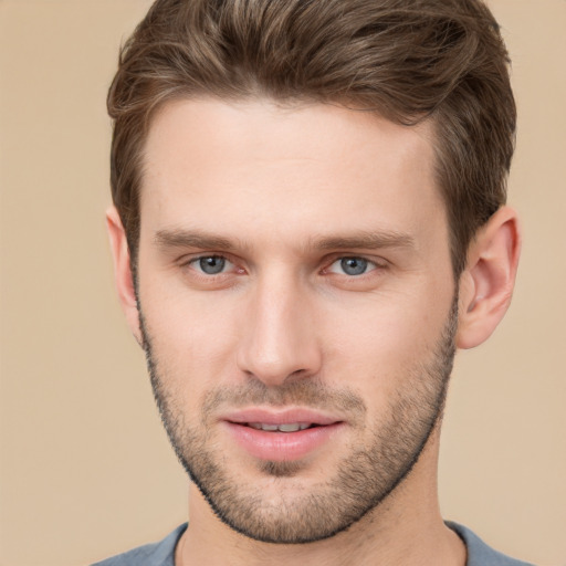 Joyful white young-adult male with short  brown hair and grey eyes