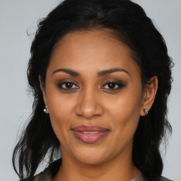 Joyful black adult female with long  brown hair and brown eyes