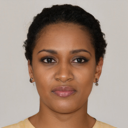 Joyful black young-adult female with short  black hair and brown eyes