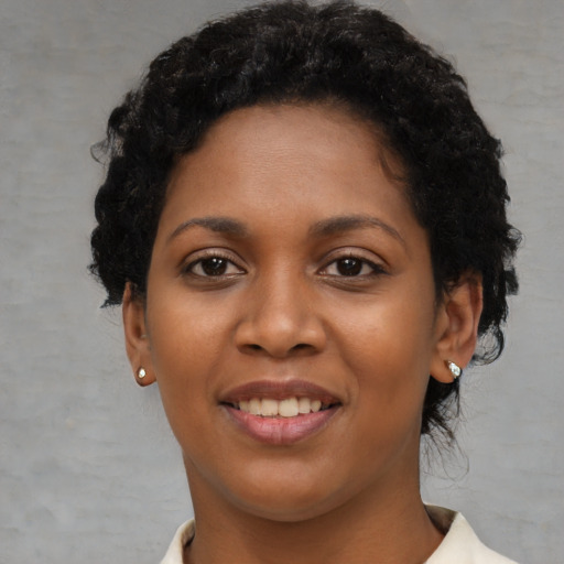 Joyful black young-adult female with short  black hair and brown eyes