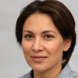 Joyful white adult female with medium  brown hair and brown eyes