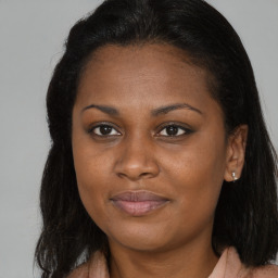 Joyful black young-adult female with long  brown hair and brown eyes