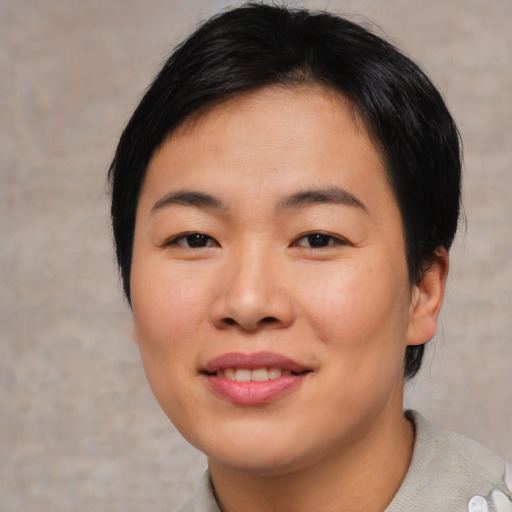 Joyful asian young-adult female with short  brown hair and brown eyes