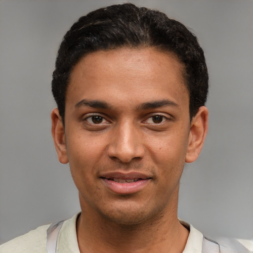 Joyful black young-adult male with short  brown hair and brown eyes