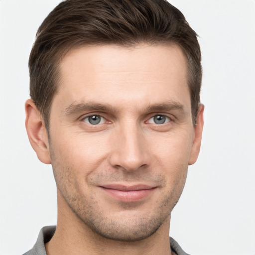 Joyful white young-adult male with short  brown hair and grey eyes