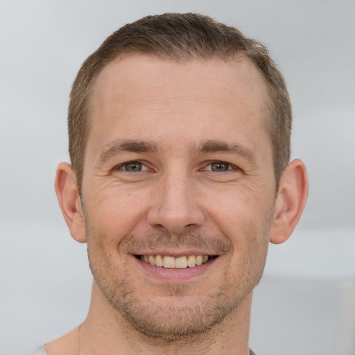 Joyful white adult male with short  brown hair and brown eyes