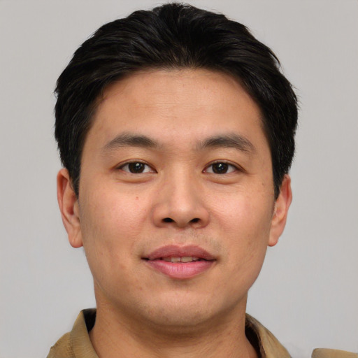 Joyful asian young-adult male with short  brown hair and brown eyes