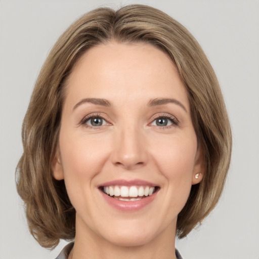 Joyful white adult female with medium  brown hair and grey eyes