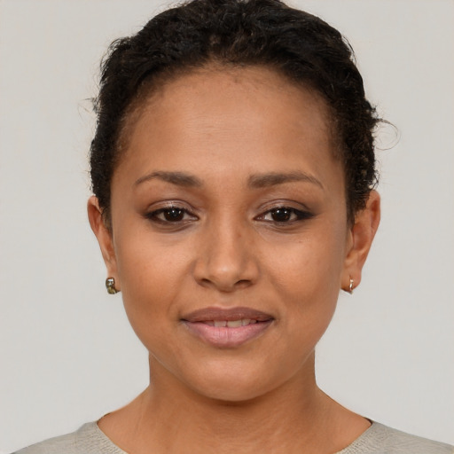 Joyful black young-adult female with short  brown hair and brown eyes