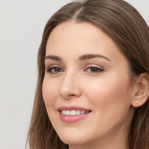 Joyful white young-adult female with long  brown hair and grey eyes