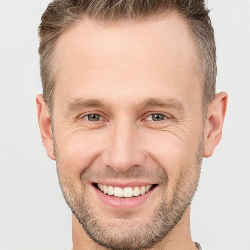 Joyful white adult male with short  brown hair and brown eyes