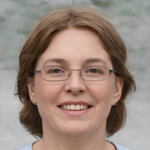 Joyful white adult female with medium  brown hair and green eyes