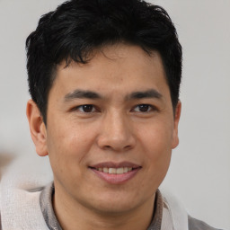 Joyful latino young-adult male with short  brown hair and brown eyes