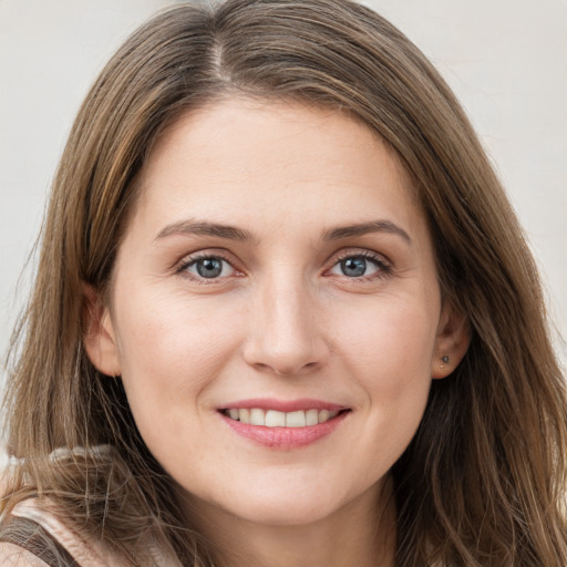 Joyful white young-adult female with long  brown hair and brown eyes