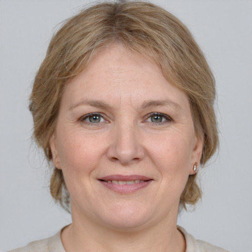 Joyful white adult female with medium  brown hair and grey eyes