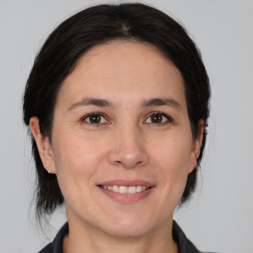 Joyful white adult female with medium  brown hair and brown eyes