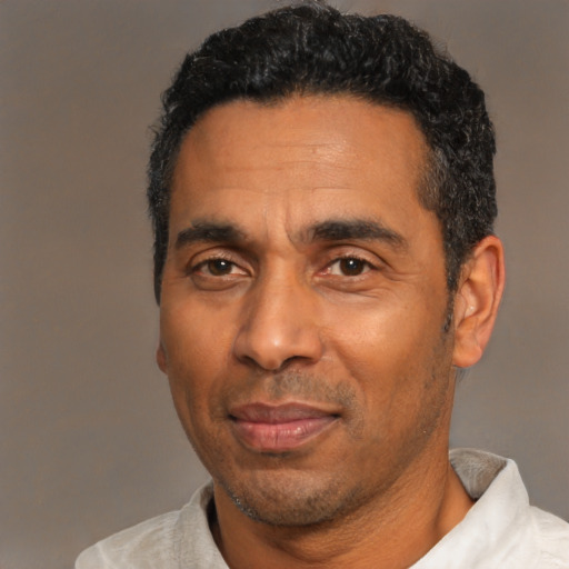 Joyful black adult male with short  black hair and brown eyes
