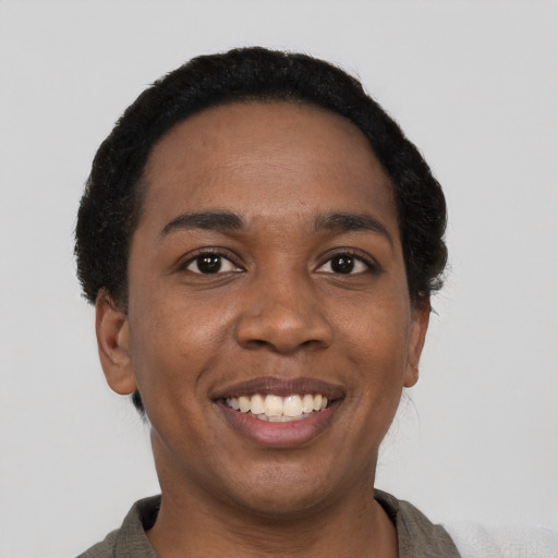 Joyful black young-adult female with short  black hair and brown eyes