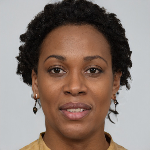 Joyful black adult female with short  brown hair and brown eyes