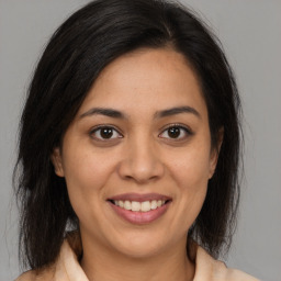 Joyful latino young-adult female with medium  brown hair and brown eyes