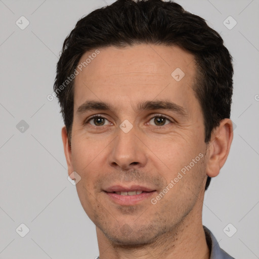 Joyful white adult male with short  black hair and brown eyes