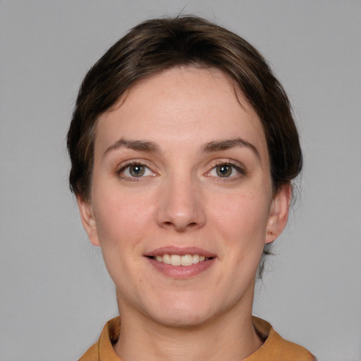 Joyful white young-adult female with short  brown hair and grey eyes