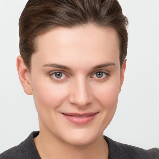 Joyful white young-adult female with short  brown hair and grey eyes